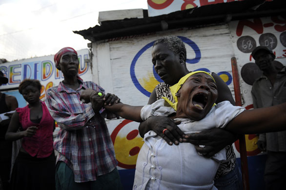 24 hours in pictures: Port-au-Prince, Haiti: Armante Cherisma cries by the body of her daughter