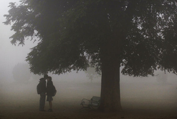 24 hours in pictures: New Delhi, India: A couple share a moment in dense fog at Lodhi Gardens 