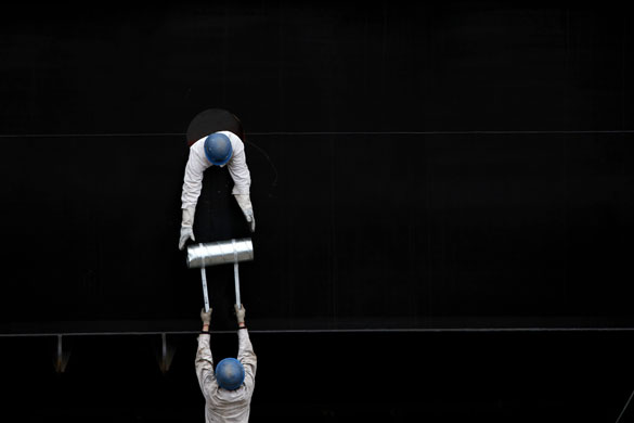 24 hours in pictures: Shanghai, China: Labourers work at a dockyard