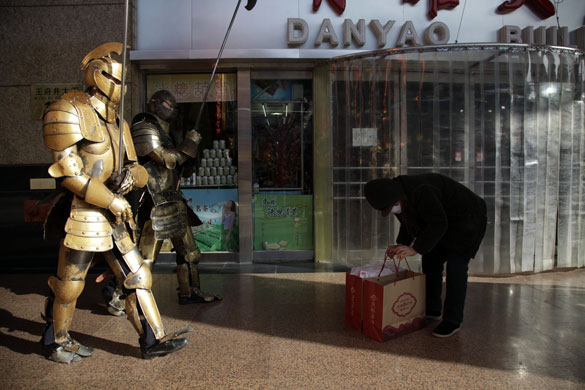 Week in Business: Men in fake armour march past at a shopping mall in Beijing, China