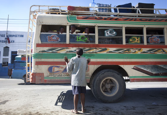 Haiti looting/bus station: At Delmas bus station a woman waves goodbye
