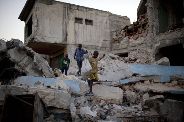 24 hours in pictures: Port-au-prince, Haiti: Children carry a bag of goods over rubble