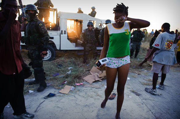 Haiti: A Haitian wipes her eye after being sprayed with tear gas by UN troops