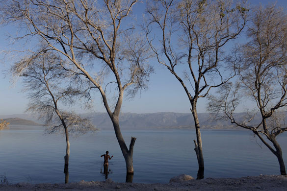 Haiti: A boy fishes in a lake in Malpasse near the border  with Dominican Republic