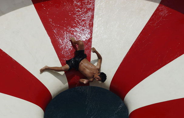 24 hours in pictures: Lima, Peru: A man slides down a slide at a water park