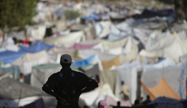Camps in Haiti: A man looks out over makeshift tents at a refugee camp in Port-au-Prince 