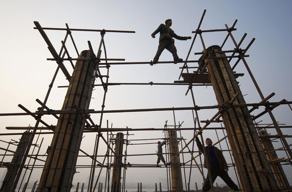 24 hours in pictures: Suining, China: Labourers install scaffolding at a construction site