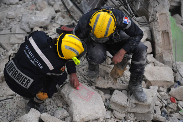 Haiti's survivors: 23 January: French search and rescue draw a diagram during their search