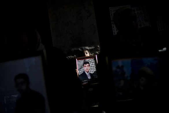 24 hours in pictures: Bethlehem, West Bank: A youth holds a picture of jailed relative