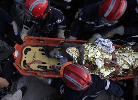 24 hours in pictures: Port-au-Prince, Haiti: Rescuers pull out a girl from a building