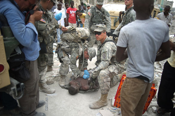 Haiti's survivors: 26 January: US paratroopers from the 82nd airborne surround a man