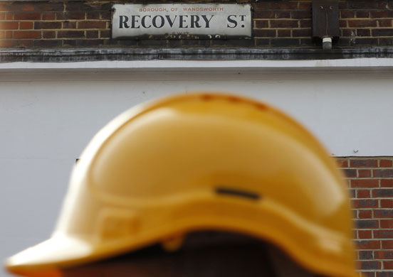 Week in business: A construction worker walks past Recovery Street in south London
