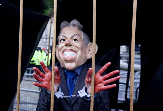 Anti-Blair protests: A protester wearing a mask depicting a caricature of Tony Blair