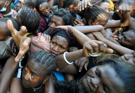 24 hours in pictures: Port-au-Prince, Haiti: A crowd of people desperately try to reach aid
