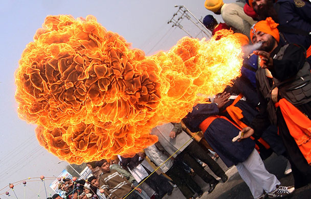 24 hours: Jammu, India: A Sikh devotee spits fire during a religious procession
