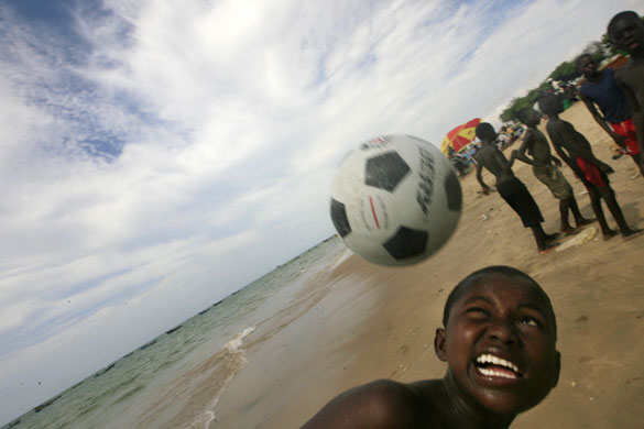 24 Hours in Pictures: -An Angolan boy plays football on the Atlantic ocean beach