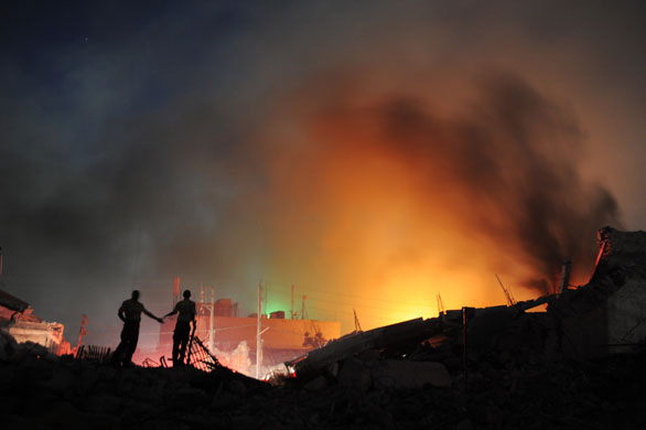 24 Hours in Pictures: Policeman watch a fire burning at the iron market in Port-au-Prince