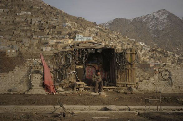 24 Hours in Pictures: A bicycle mechanic waits for customers in front of his shop in Kabul