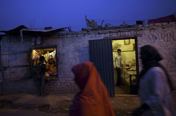 24 hours in pictures: Pakistani women, walk by a jewellery shop and a grocery store