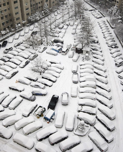 snow in korea and china: Vehicles are seen parked after heavy snowfall in Seoul