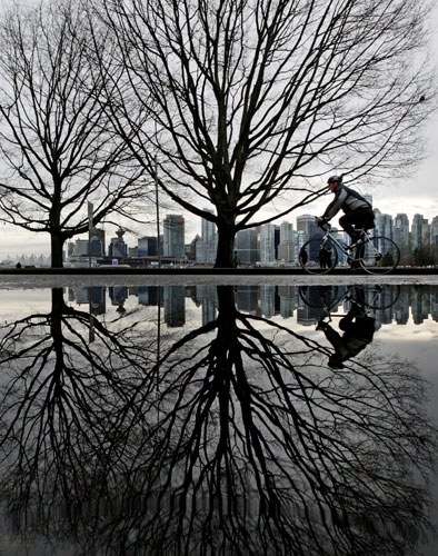 24 hours in pictures: Vancouver, Canada: A man is reflected in a puddle of water