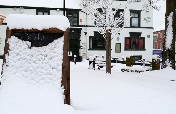 UK weather update: Altrincham: A sign advertising food is covered after a very heavy snowfall