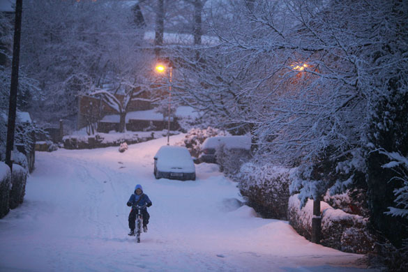 UK weather update:  A newspaper delivery boy battles through the snow n Ramsbottom