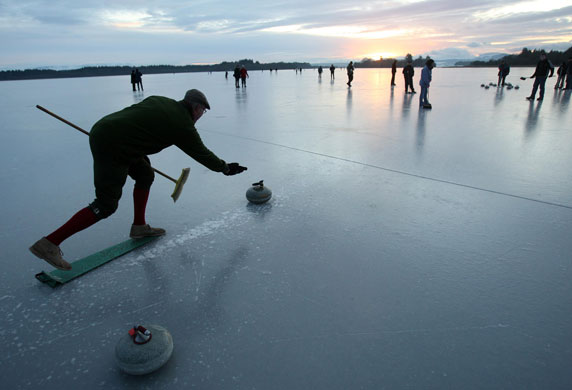 UK weather update: A Curler throws a stone on the Lake of Menteith during a curling match