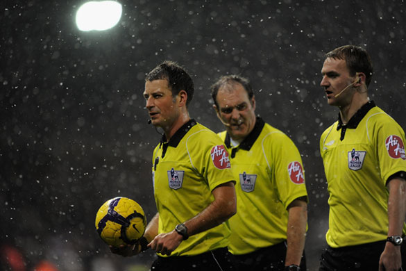 Snow: Referee Mark Clattenburg and his assistants feel the cold