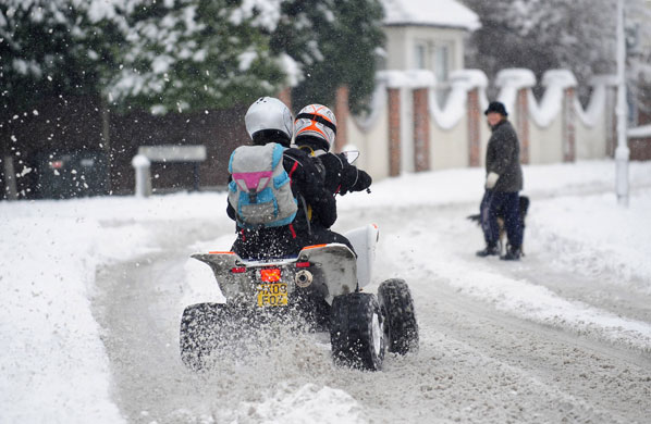 Winter weather: A couple use a quad bike to travel through the snow in Farnborough