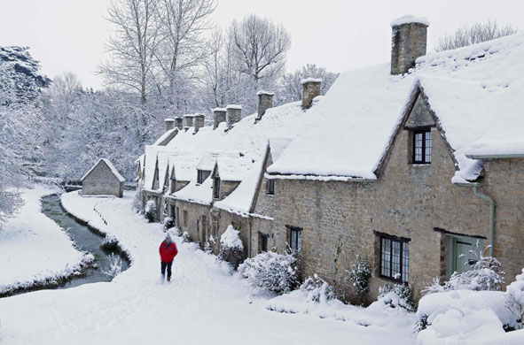 Winter weather:  A man walks through the snow past Arlington Row cottages