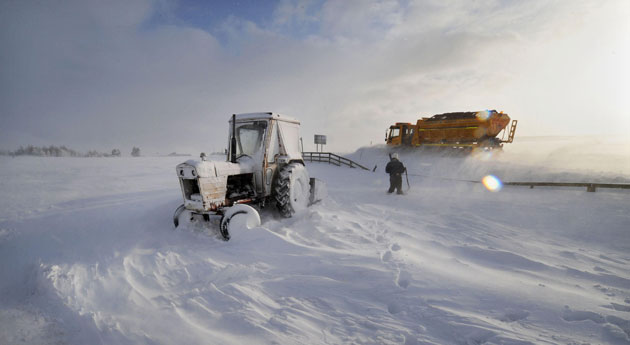 Winter weather: Denshaw, Oldham, 6 January: A farmer and his tractor in snow drifts
