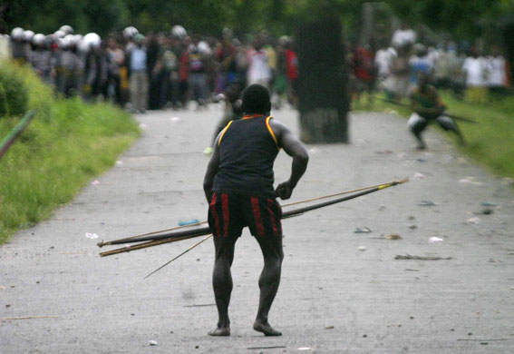 24 hours in pictures: A Dani tribesman prepares to attack the Damal trib in Papua, Indonesia
