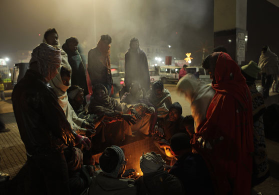 24 hours in pictures: Gaya, India: People sit around a fire at a railway station