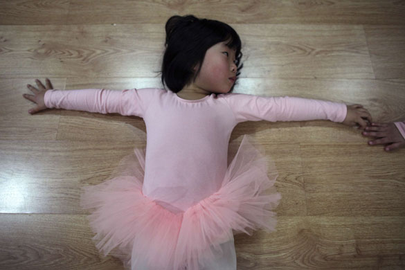 24 hours in pictures: A ballet student stretches during her lesson at a sports centre in Shanghai