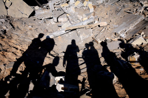 24 Hours in Pictures: Shadows of Palestinian people in the rubble of a destroyed building