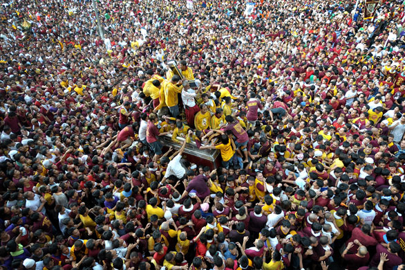 24 Hours in Pictures: Barefoot Roman Catholic devotees swarm around a 'Black Nazarene' float