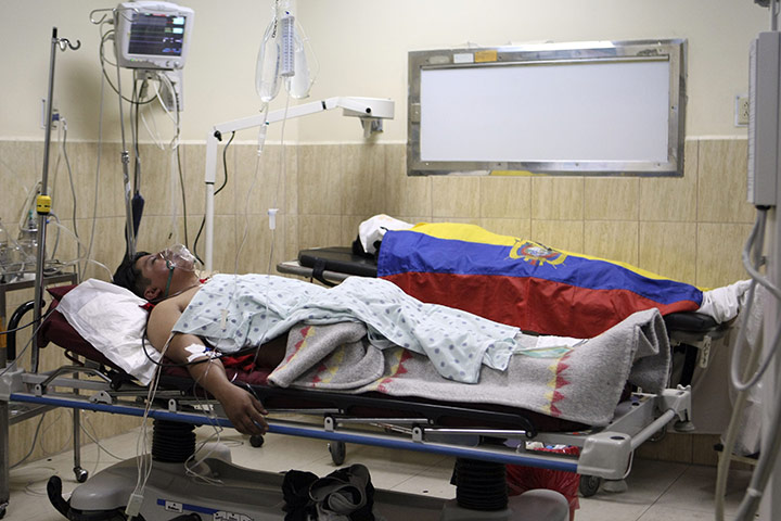 Ecuador Crisis Update: An injured police officer, front, lies injured in Quito