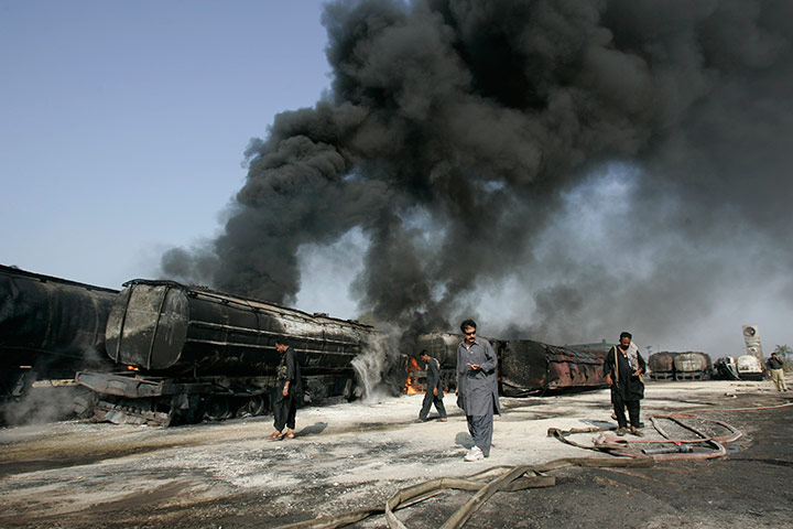 24 hours in pictures: Police look for evidence beside still smoldering oil trucks in Shikarpur