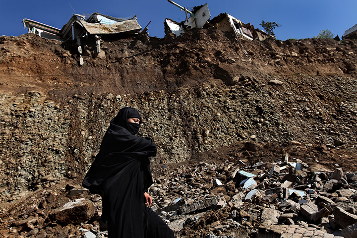 Swat: Swat Valley residents pass along a road under the remains of Jare village