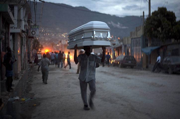 Ramon Espinosa: A man carries a coffin through the street in Port-au-Prince, Haiti