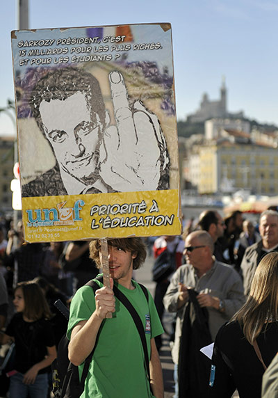 French Strikes: A man holds a banner 