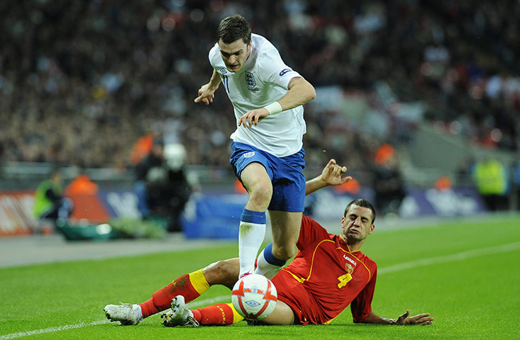 England v Montenegro 2: Adam Johnson hurdles over Jovanovic