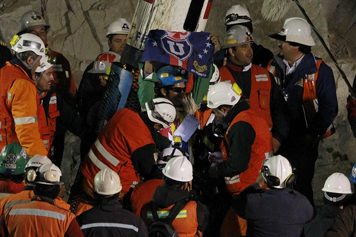 chile miners rescued: Miner Sanchez celebrates with the flag ofUniversidad de Chile