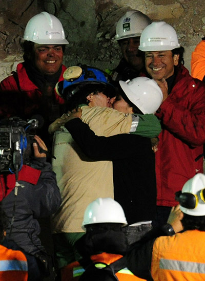 Chile miners rescue: Osman Araya, the sixth miner out, kisses his wife Angelica