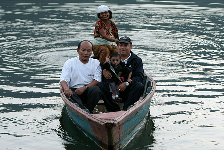 Khagendra Thapa Magar: Khagendra Thapa Magar sits with his father Rup Bahadur Thapa Magar in boat