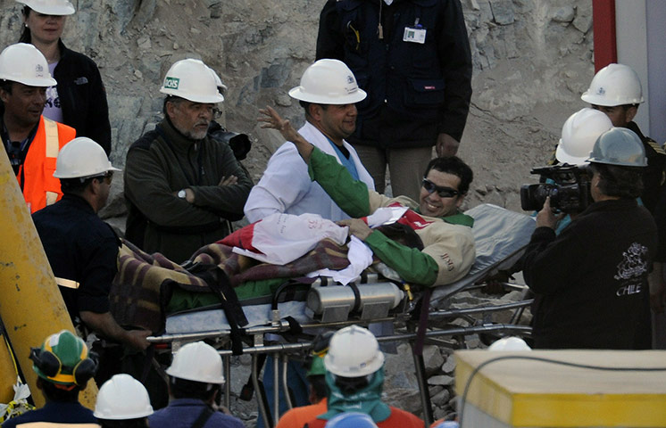 Rescued Chile miners: 26th Chilean miner Claudio Acuna waves as he taken on a trolley