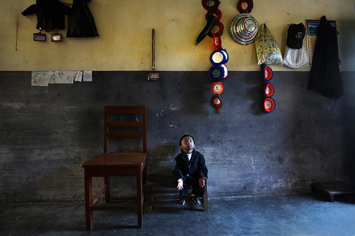 24 hours:  Khagendra Thapa Magar sits on a small stool inside his home