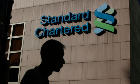 A man walks pass the Standard Chartered Bank headquarters in Hong Kong.