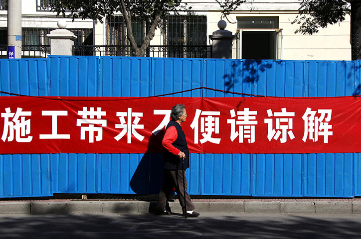 Communist Party Chinaq: A woman walks past a banner in Beijing